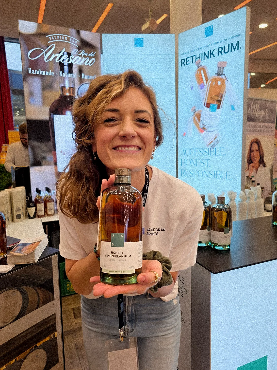 Nina Vorster präsentiert Jack Crap Spirits Honest Venezuelan Rum auf einem Messestand mit Rethink Rum Banner